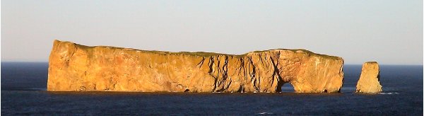 Percé Rock at Percé, Quebec, with its distinctive bow shape (left) waterline hole (right).